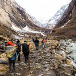 A group of trekkers walking towards Annapurna base camp in Nepal along a river with Zenith Sanctuaries